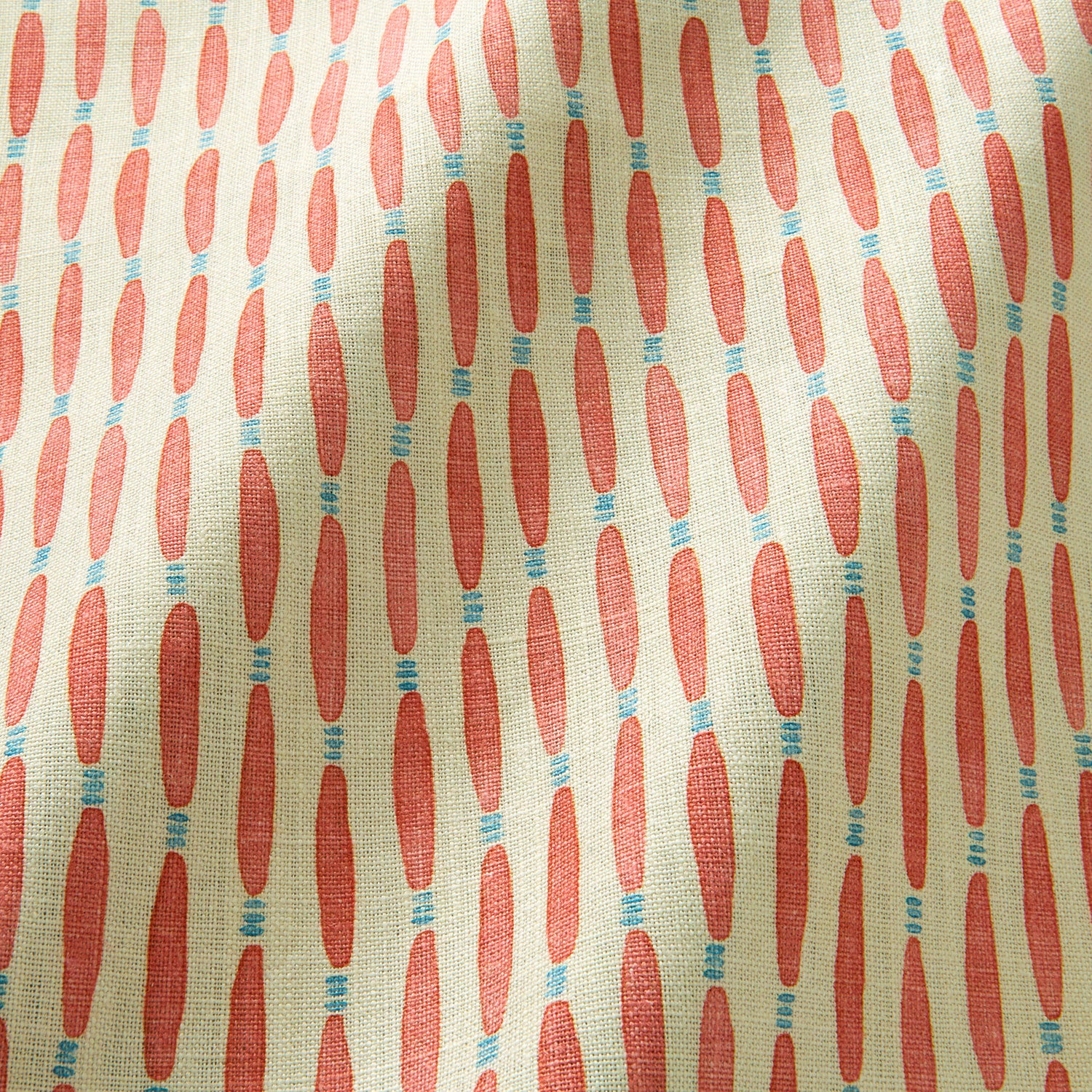 A printed linen fabric sample in orange, blue, and off white featuring a Japanese print.