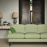 Sofa upholstered in a printed linen fabric in green and off white featuring a Japanese print.