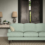 Sofa upholstered in a printed linen fabric in blue and off white featuring a Japanese print.