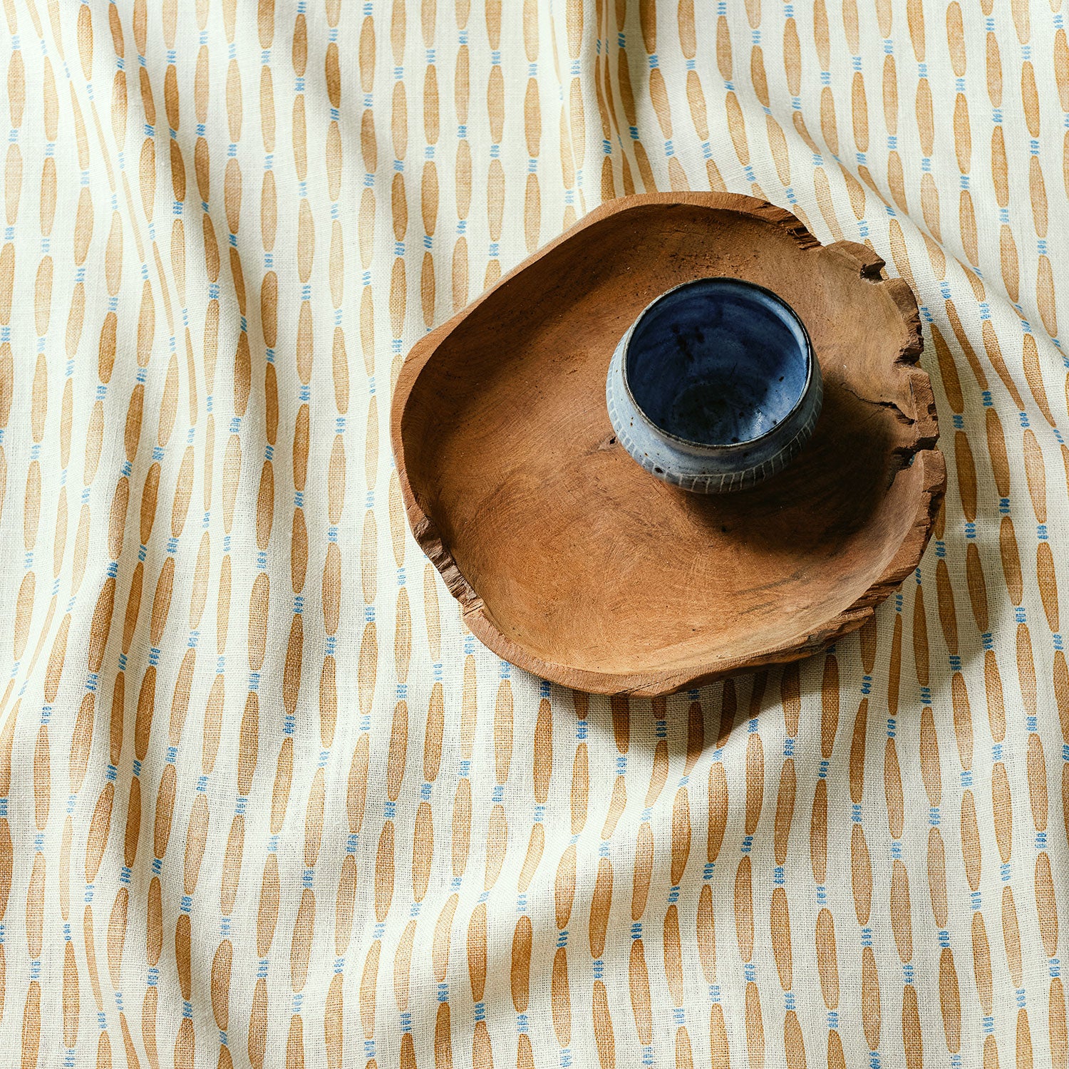 A printed linen fabric sample in yellow, blue and off white featuring a Japanese print.