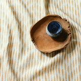 A printed linen fabric sample in yellow, blue and off white featuring a Japanese print.