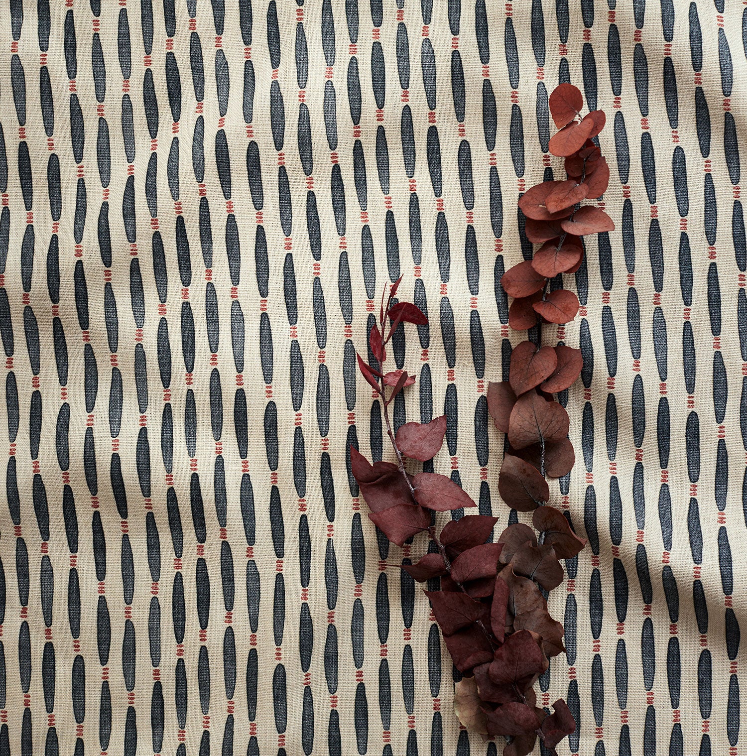 A printed linen fabric sample in blue, orange, and off white featuring a Japanese print.