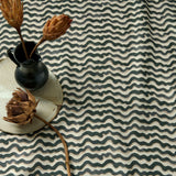 A printed linen fabric sample in black, brown and off white featuring a sound wave pattern