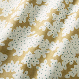A printed linen fabric sample in yellow, blue and off white featuring a stylized coral pattern.