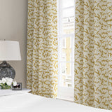 Curtains made from a printed linen fabric sample in yellow, blue and off white featuring a stylized coral pattern.