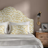 Headboard upholstered in a printed linen fabric sample in yellow, blue and off white featuring a stylized coral pattern.