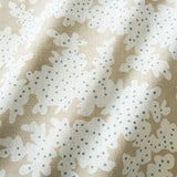 A printed linen fabric sample in brown, blue and off white featuring a stylized coral pattern.
