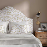 Headboard upholstered in a printed linen fabric sample in brown, blue and off white featuring a stylized coral pattern.