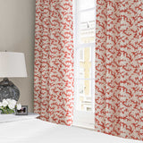 Curtains made from a printed linen fabric sample in red, brown and off white featuring a stylized coral pattern.