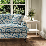 Sofa upholstered in a printed linen fabric sample in blue, black and off white featuring a stylized coral pattern.
