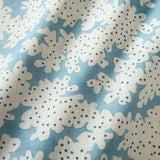 A printed linen fabric sample in blue, black and off white featuring a stylized coral pattern.