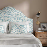 Headboard upholstered in a printed linen fabric sample in blue, black and off white featuring a stylized coral pattern.