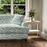 Sofa upholstered in a printed linen fabric sample in blue, black and off white featuring a stylized coral pattern.