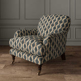 Chair upholstered in a printed linen fabric sample in blue, orange and off white featuring a stylized fern pattern.