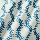 A printed linen fabric sample in blue and off white featuring a stylized fern pattern.