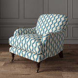 Chair upholstered in a printed linen fabric sample in blue and off white featuring a stylized fern pattern.
