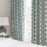 Curtains made from a printed linen fabric sample in blue and off white featuring a stylized fern pattern.