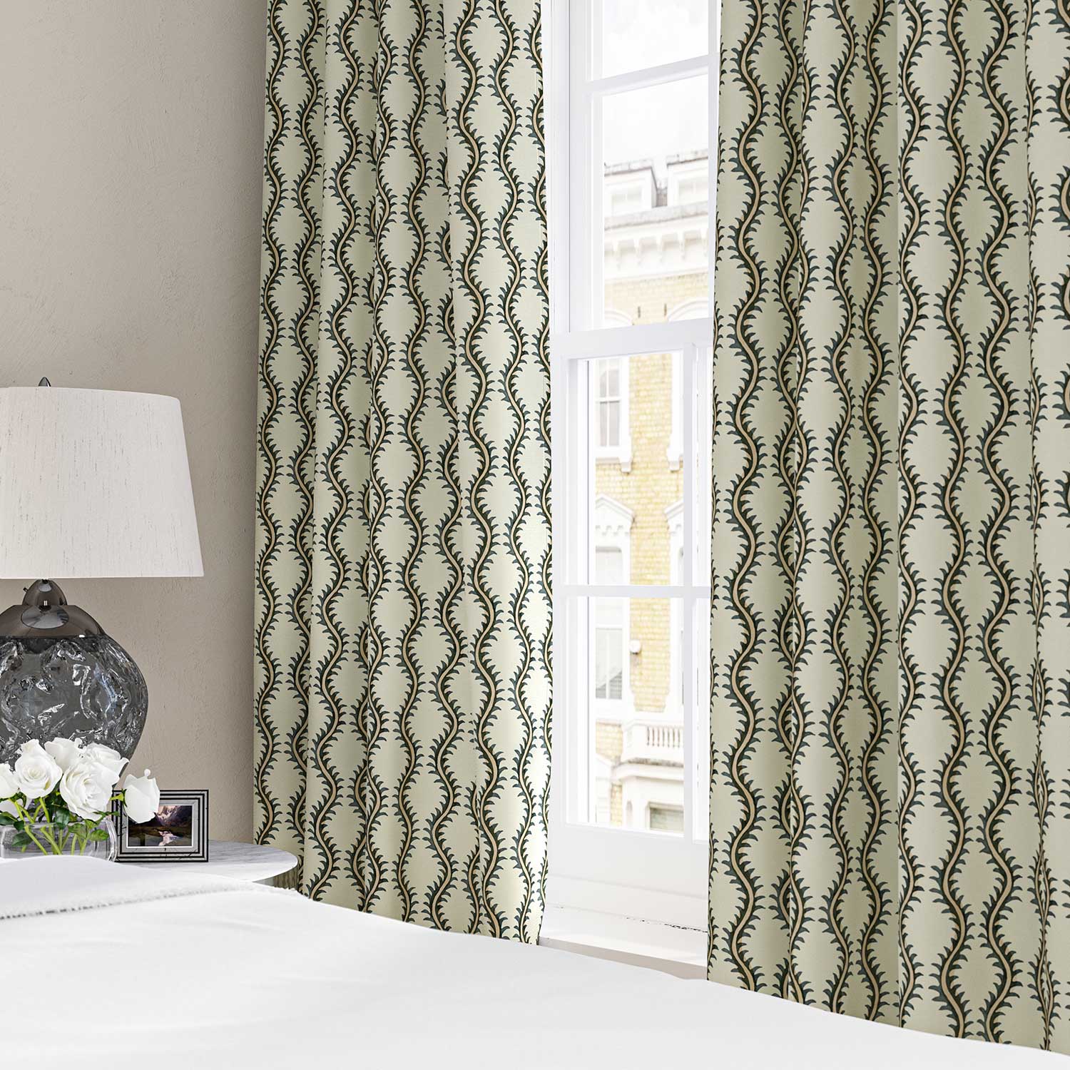 Curtains made from a printed linen fabric sample in green and off white featuring a stylized fern pattern.