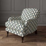Chair upholstered in a printed linen fabric sample in blue and off white featuring a stylized fern pattern.