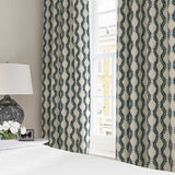 Curtains made from a printed linen fabric sample in blue and off white featuring a stylized fern pattern.