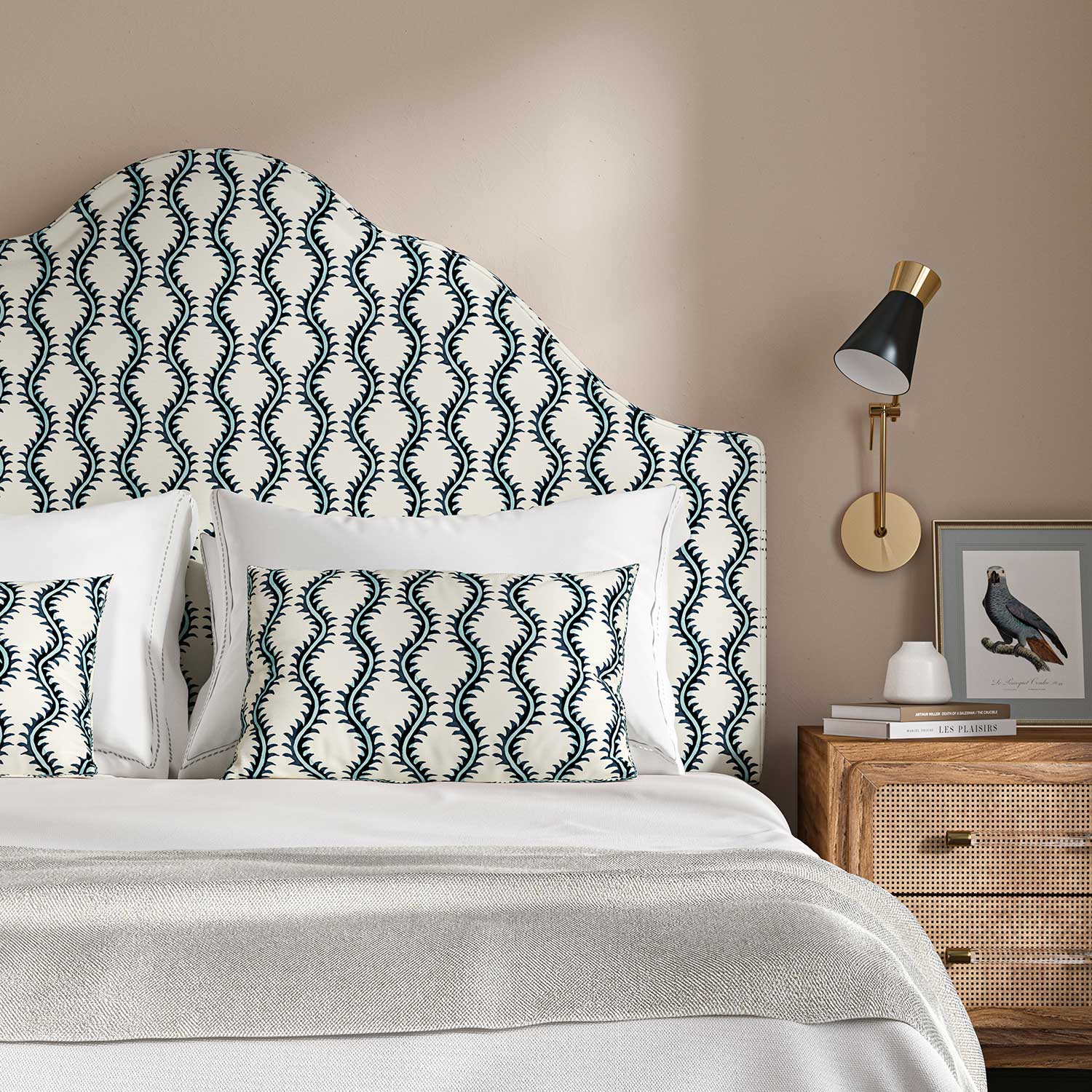 Headboard upholstered in a printed linen fabric sample in blue and off white featuring a stylized fern pattern.