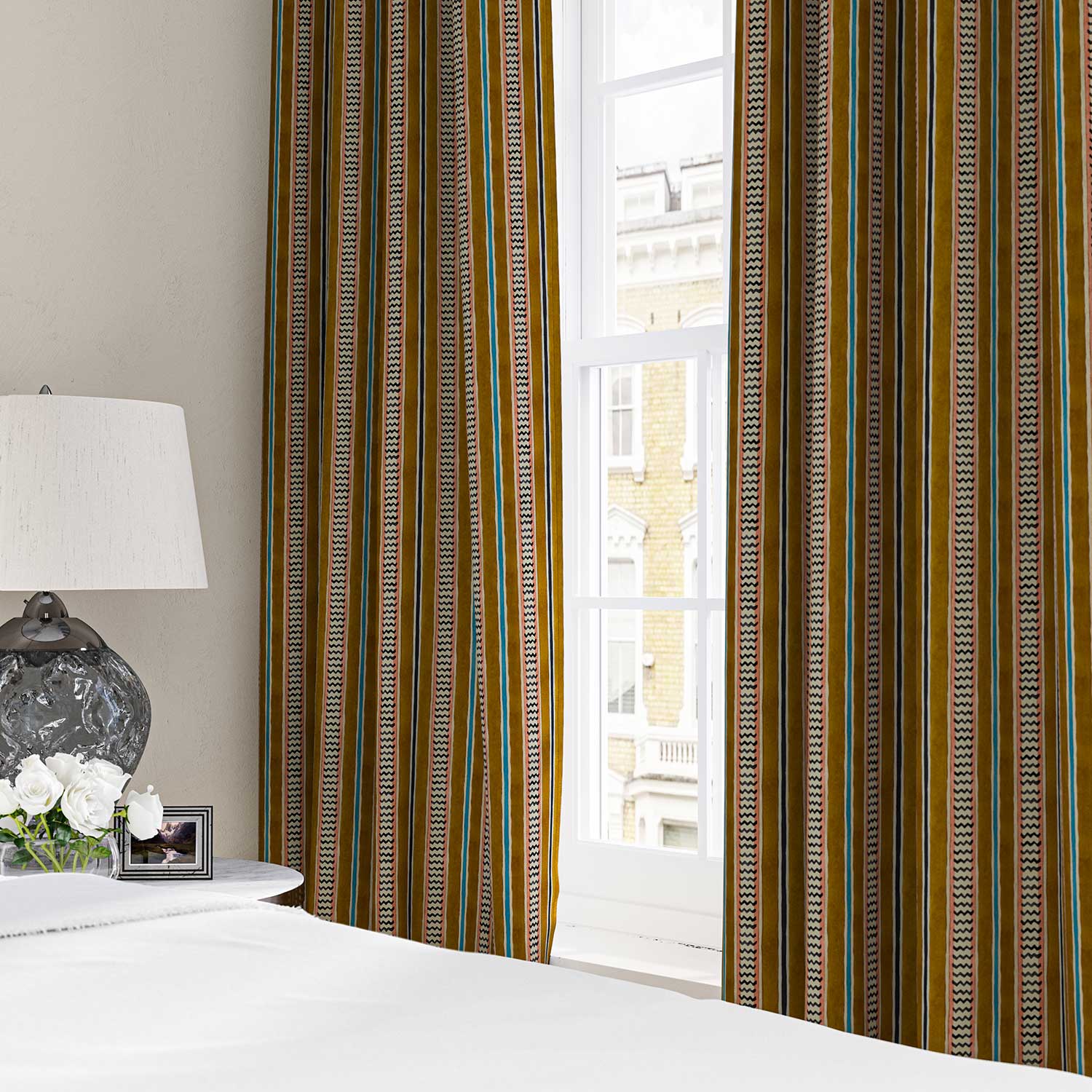 Curtains in a multicoloured printed linen fabric featuring stripes, wavy edges and zigzags.