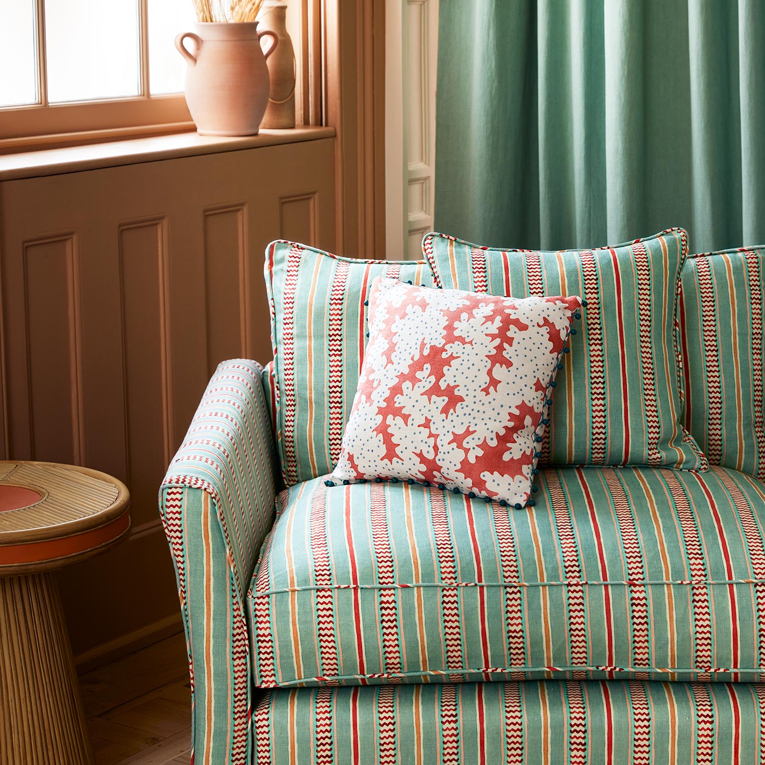 Armchair in a multicoloured – blue, red and pink – printed linen fabric featuring stripes, wavy edges and zigzags.