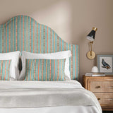 Headboard in a multicoloured – blue, red and pink – printed linen fabric featuring stripes, wavy edges and zigzags.