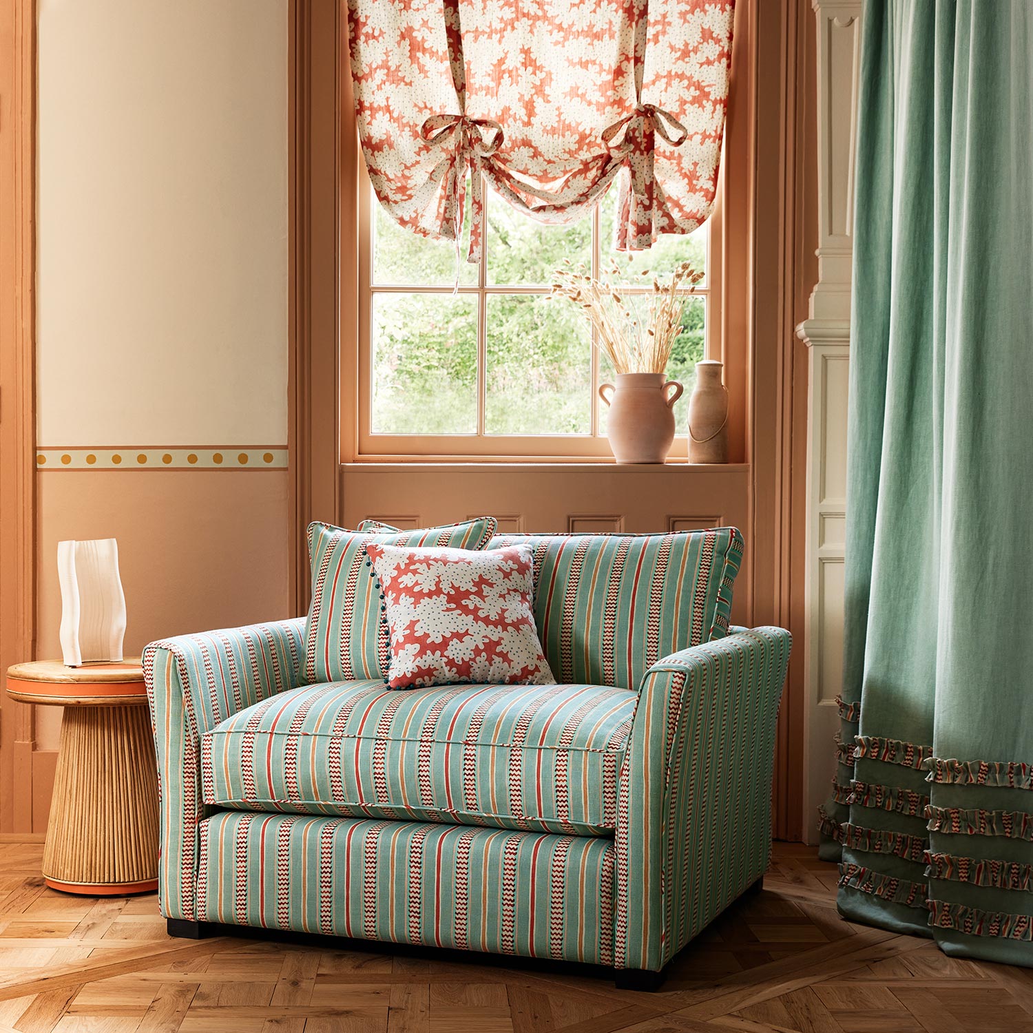 Armchair in a multicoloured – blue, red and pink – printed linen fabric featuring stripes, wavy edges and zigzags.