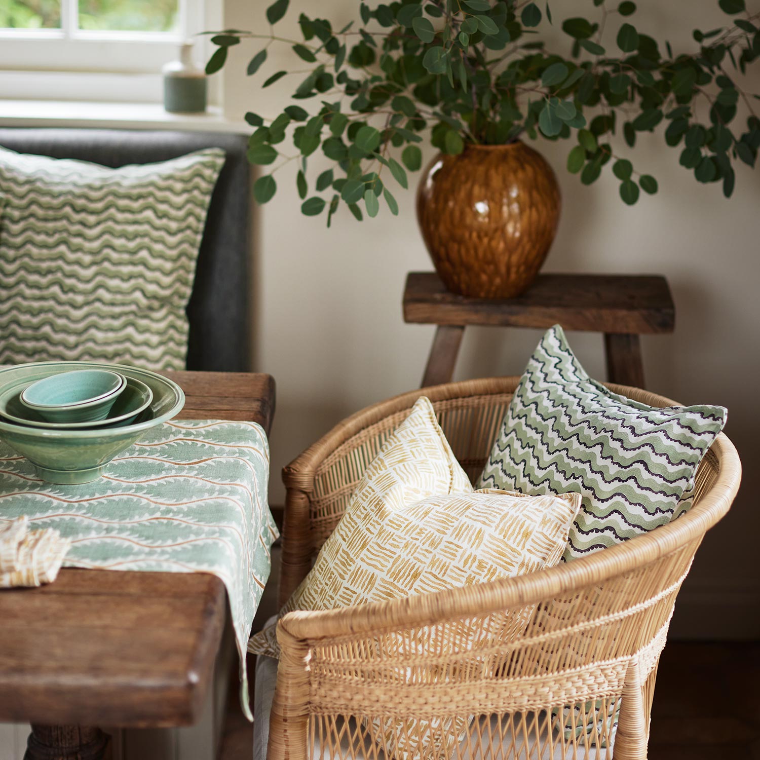Cushions made from a printed linen fabric in green, black and off white featuring a sound wave pattern