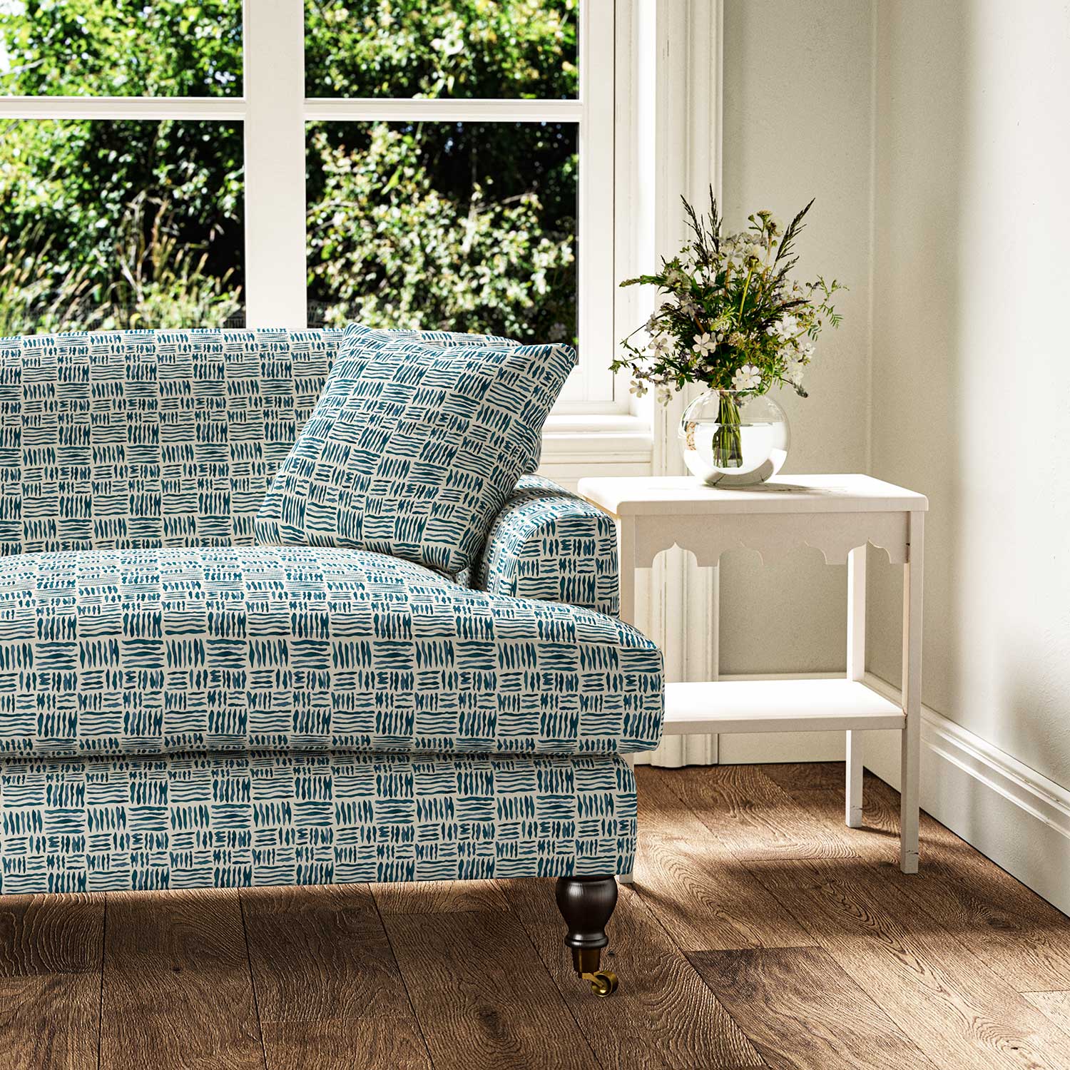 Sofa upholstered in a printed linen fabric in blue and off white featuring a basketweave pattern.