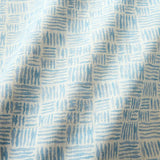 A printed linen fabric sample in blue and off white featuring a basketweave pattern.