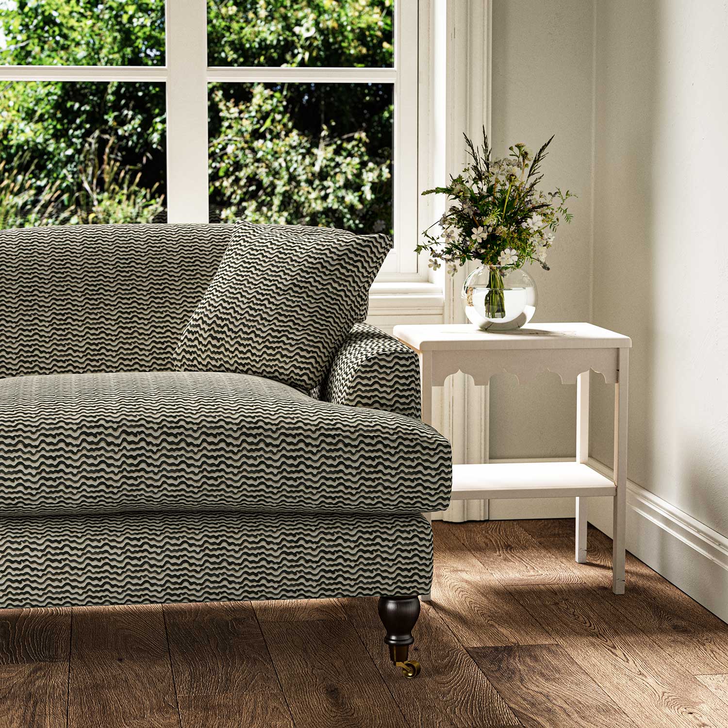 Sofa upholstered in a printed linen fabric in black, brown and off white featuring a sound wave pattern