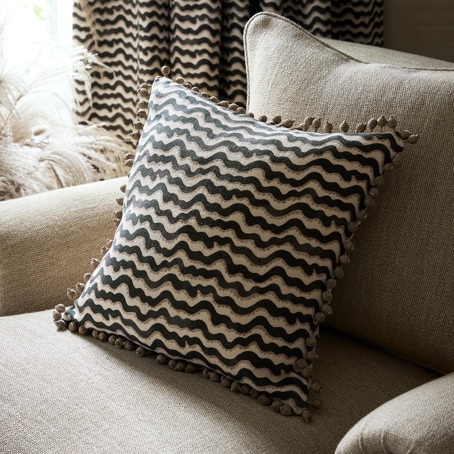 Cushion made from a printed linen fabric in black, brown and off white featuring a sound wave pattern