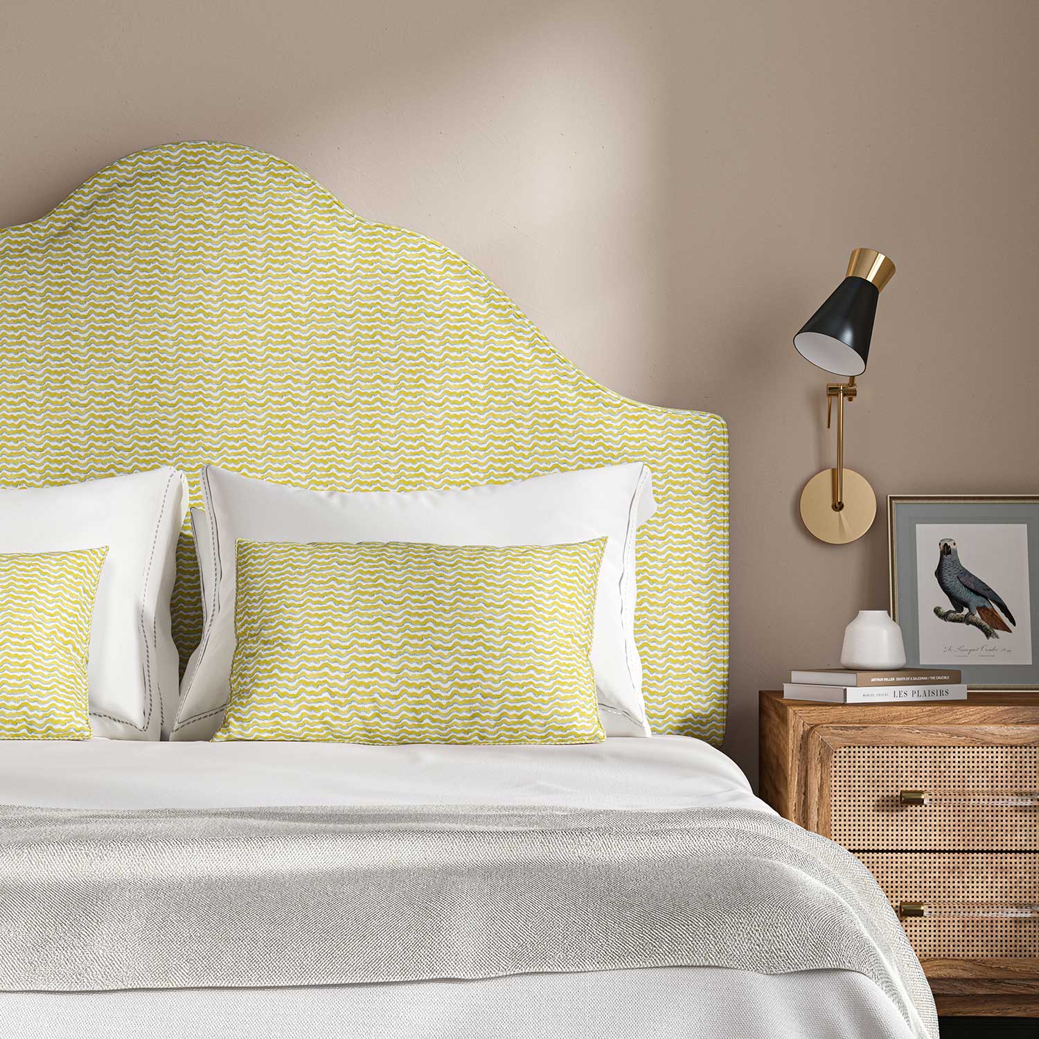 Headboard upholstered in a printed linen fabric sample in yellow, blue and off white featuring a sound wave pattern