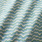 A printed linen fabric sample in blue, green and off white featuring a sound wave pattern