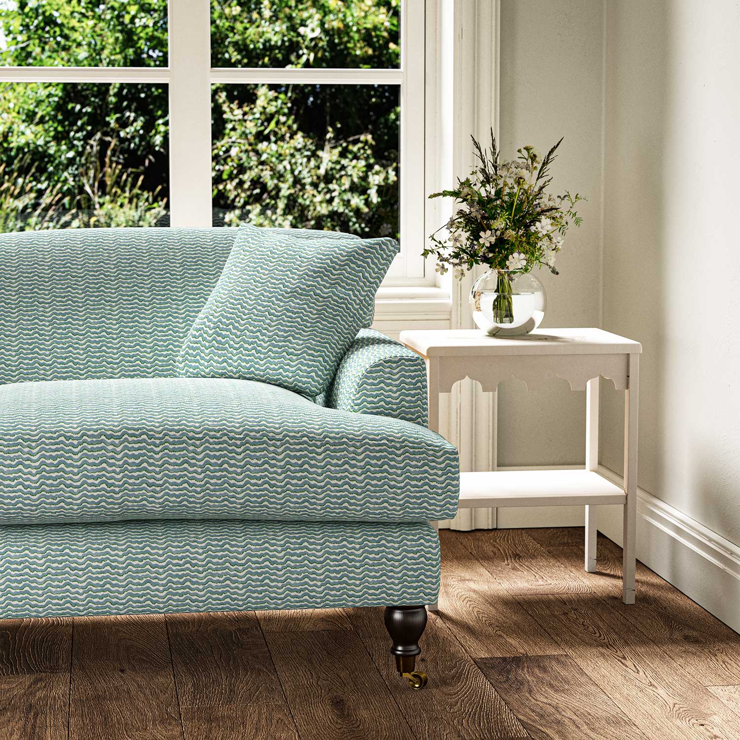 Sofa upholstered in a printed linen fabric in blue, green and off white featuring a sound wave pattern