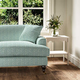 Sofa upholstered in a printed linen fabric in blue, green and off white featuring a sound wave pattern