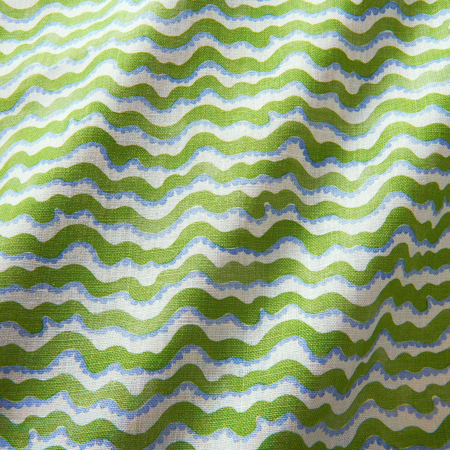 A printed linen fabric sample in blue, green and off white featuring a sound wave pattern