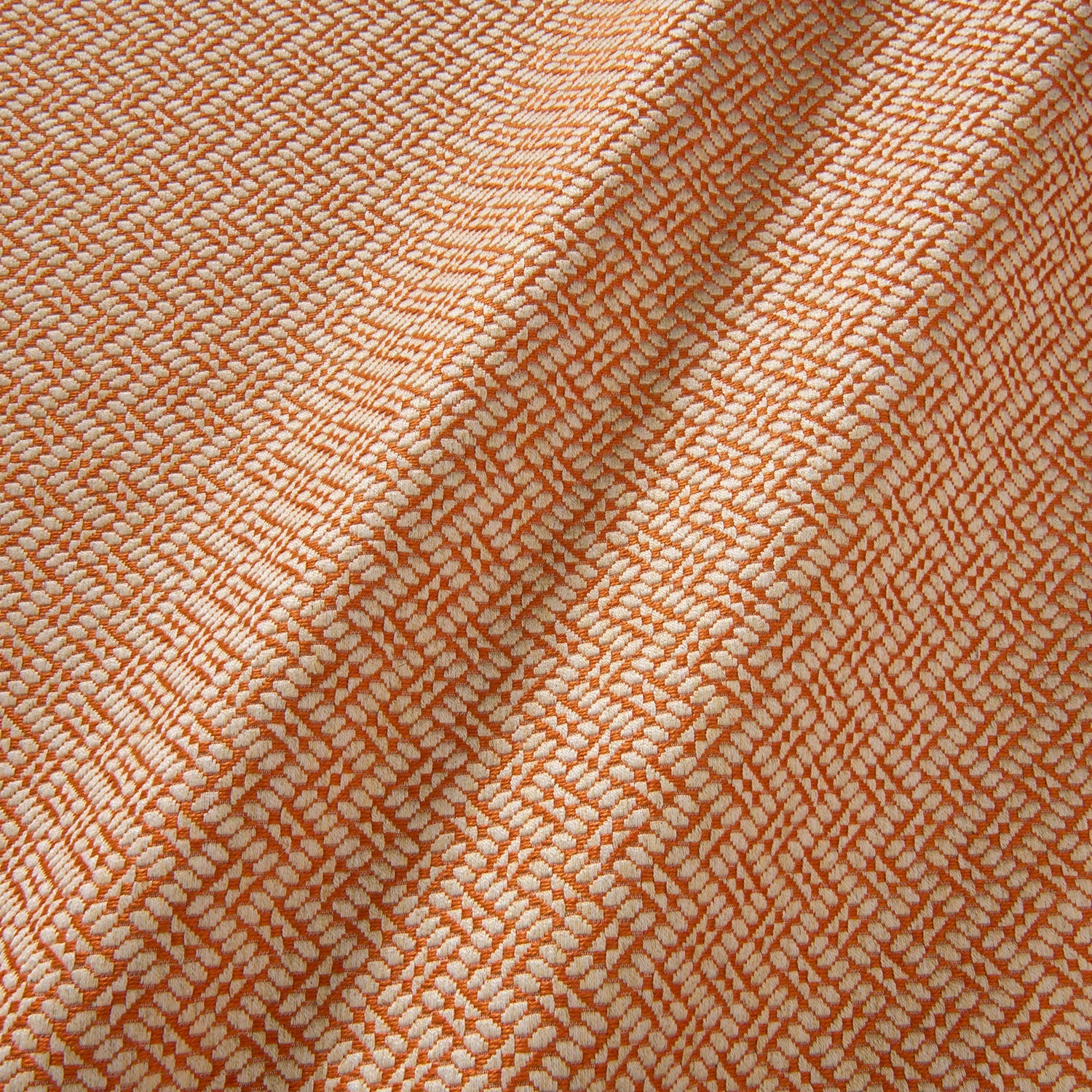 A woven fabric sample in orange and off-white featuring a trellis pattern.