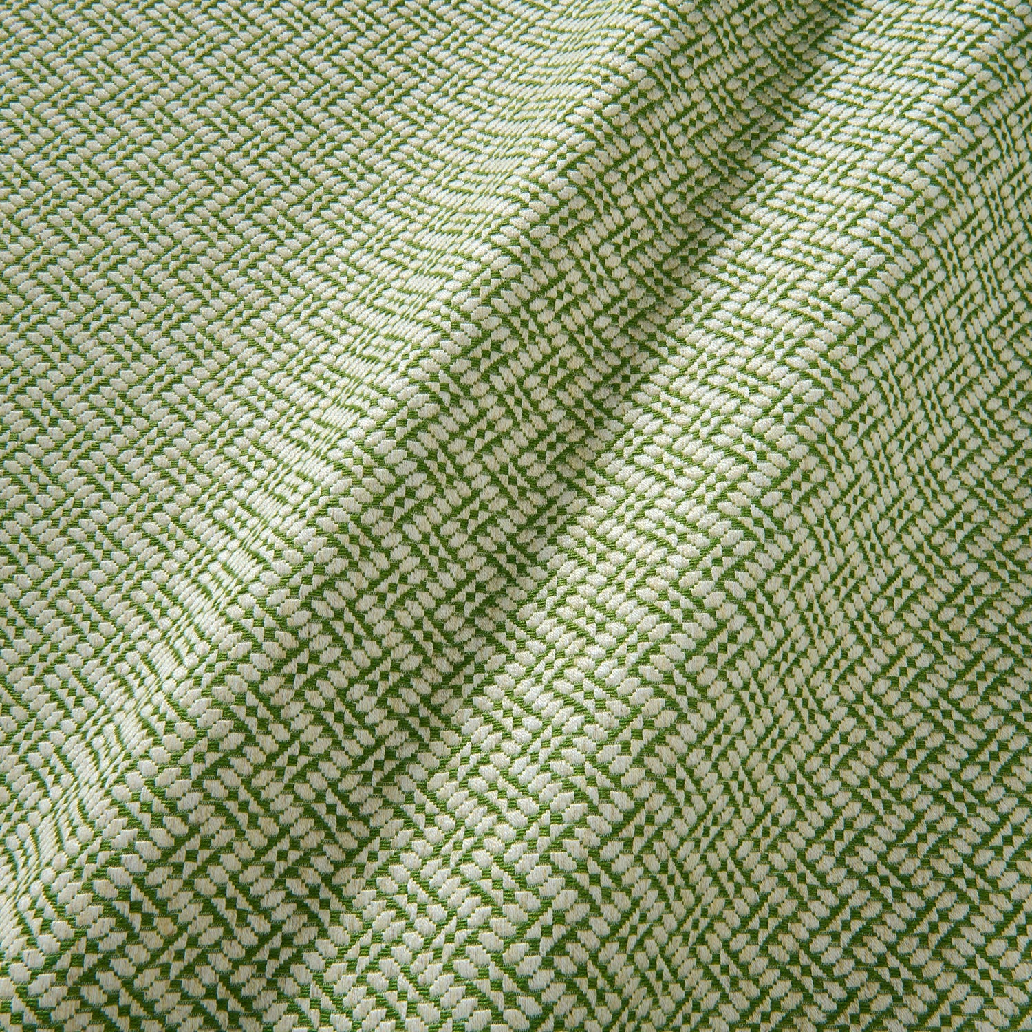 A woven fabric sample in green and off-white featuring a trellis pattern.