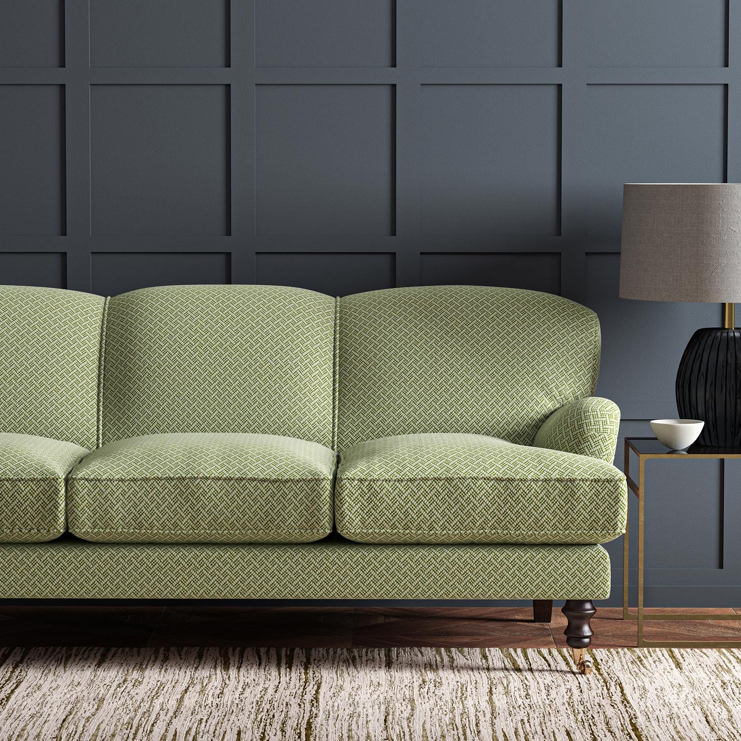 Sofa upholstered in a green and off-white woven fabric featuring a trellis pattern.