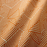A woven fabric sample in orange and off-white featuring a geometric pattern.