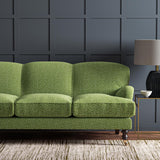 Sofa upholstered in a green and off-white woven fabric featuring a wavy pattern.