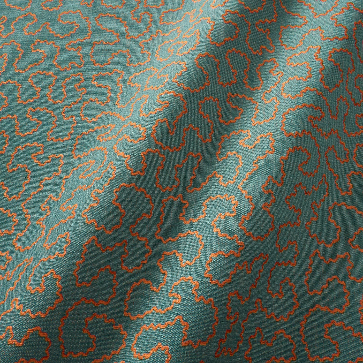 A woven fabric sample in blue and orange featuring a coral wavy pattern.