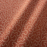 A woven fabric sample in red and off-white featuring a wavy pattern.