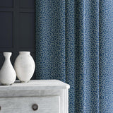 Curtain in blue and off-white woven fabric featuring a wavy pattern.