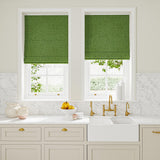 Blinds in green woven fabric featuring a wavy pattern.