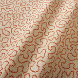 A woven fabric sample in red and beige featuring a wavy pattern.