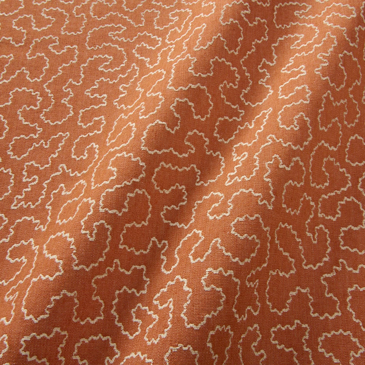 A woven fabric sample in orange and off-white featuring a wavy pattern.